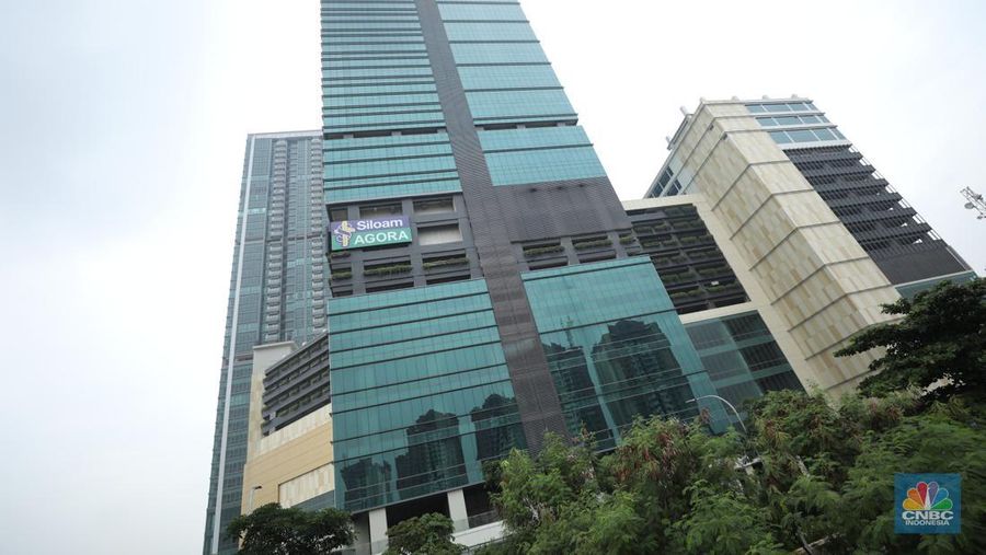 Warga melewati jembatan penyebrangan orang (jpo) dengan latar belakang Lippo Mall East Side di Cempaka Putih, Jakarta Pusat, Jumat (7/7/2022). Pada tahun 2022 ini Lippo Mall East Side di Cempaka Putih, Jakarta Pusat diproyeksikan selesai. Mal ini dibangun oleh Lippo Karawaci dengan luasan 44 ribu meter persegi dan bangunan ini menjadi satu dengan apartemen. (CNBC Indonesia/ Tri Susilo)