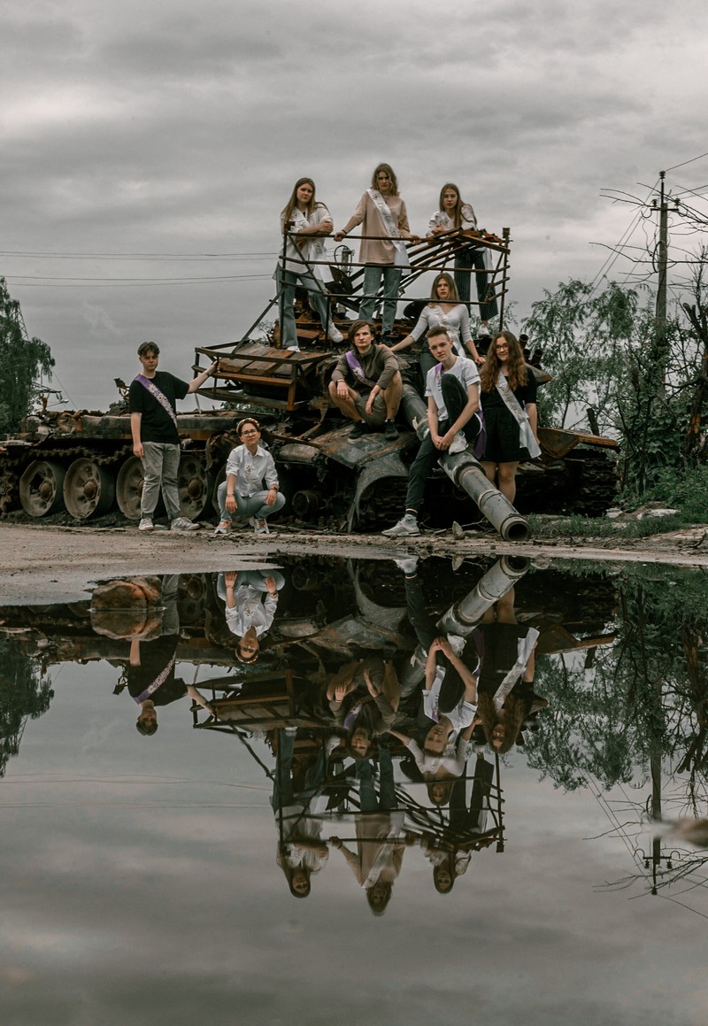 UKRAINE-CRISIS/GRADUATION-ALBUM Students pose in front of a destroyed military vehicle for a high school graduation photoshoot, as Russia's attack on Ukraine continues, in Chernihiv, Ukraine, June 5, 2022. Picture taken on June 5, 2022. Instagram/@senykstas/Handout via REUTERS THIS IMAGE HAS BEEN SUPPLIED BY A THIRD PARTY. MANDATORY CREDIT. NO RESALES. NO ARCHIVES.