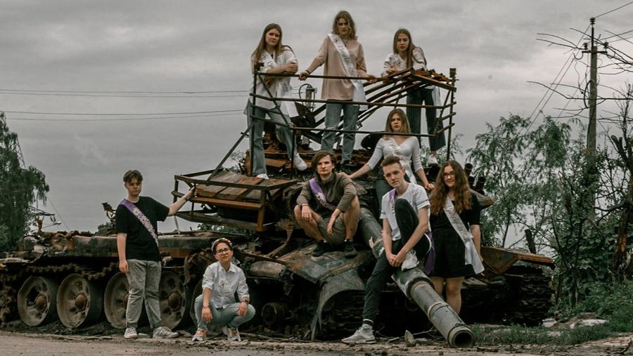 Students pose in front of a destroyed military vehicle for a high school graduation photoshoot, as Russia's attack on Ukraine continues, in Chernihiv, Ukraine, June 5, 2022. Picture taken on June 5, 2022. Instagram/@senykstas/Handout via REUTERS  THIS IMAGE HAS BEEN SUPPLIED BY A THIRD PARTY. MANDATORY CREDIT. NO RESALES. NO ARCHIVES.