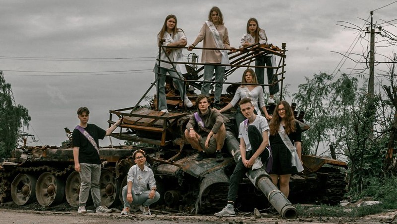 Students pose in front of a destroyed military vehicle for a high school graduation photoshoot, as Russia's attack on Ukraine continues, in Chernihiv, Ukraine, June 5, 2022. Picture taken on June 5, 2022. Instagram/@senykstas/Handout via REUTERS  THIS IMAGE HAS BEEN SUPPLIED BY A THIRD PARTY. MANDATORY CREDIT. NO RESALES. NO ARCHIVES.