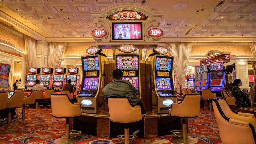 TOPSHOT - In this photo taken on March 5, 2019, visitors use slot machines in a casino in Macau. - The trade war may have sent ripples of uncertainty through the world's second-largest economy but one corner of China has so far remained steadfastly buoyant -- the gambling enclave of Macau. (Photo by Anthony WALLACE / AFP) / TO GO WITH Macau-gaming-economy-tourism, FOCUS by Yan Zhao with Jerome Taylor (Photo by ANTHONY WALLACE/AFP via Getty Images)