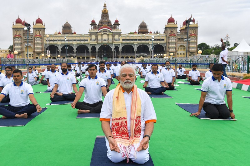 India's Prime Minister Narendra Modi (C) performs yoga with others to celebrate the International Day of Yoga in front of the Mysore Palace in Mysore on June 21, 2022. (Photo by Manjunath Kiran / AFP) (Photo by MANJUNATH KIRAN/AFP via Getty Images)