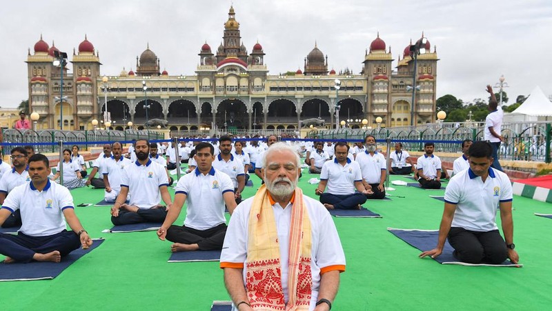 India's Prime Minister Narendra Modi (C) performs yoga with others to celebrate the International Day of Yoga in front of the Mysore Palace in Mysore on June 21, 2022. (Photo by Manjunath Kiran / AFP) (Photo by MANJUNATH KIRAN/AFP via Getty Images)