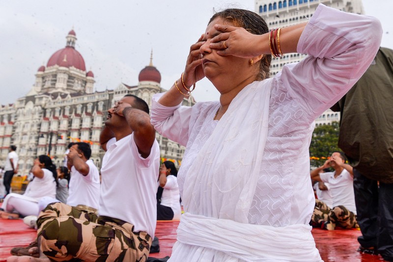 India's Prime Minister Narendra Modi (C) performs yoga with others to celebrate the International Day of Yoga in front of the Mysore Palace in Mysore on June 21, 2022. (Photo by Manjunath Kiran / AFP) (Photo by MANJUNATH KIRAN/AFP via Getty Images)