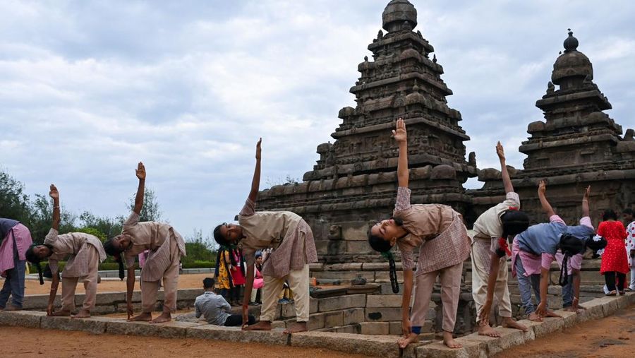 Students participate in a yoga session to celebrate the International Day of Yoga at the Shore Temple in Mahabalipuram on June 21, 2022. (Photo by Arun SANKAR / AFP) (Photo by ARUN SANKAR/AFP via Getty Images)