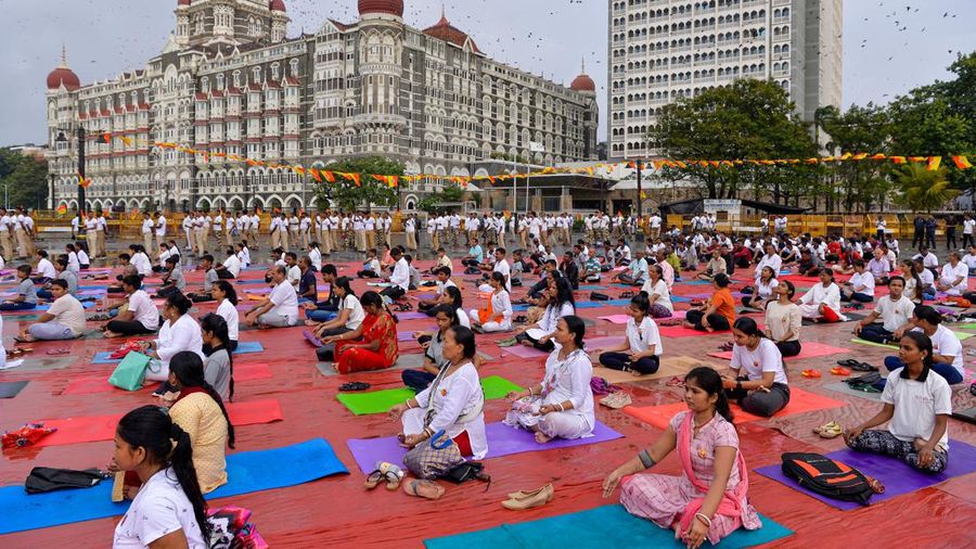 People participate in a mass yoga session to celebrate the International Day of Yoga at the Gateway of India in Mumbai on June 21, 2022. (Photo by Indranil MUKHERJEE / AFP) (Photo by INDRANIL MUKHERJEE/AFP via Getty Images)