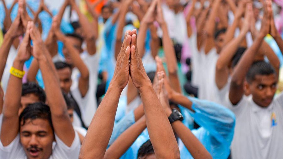 People participate in a mass yoga session to celebrate the International Day of Yoga in Mumbai on June 21, 2022. (Photo by Indranil MUKHERJEE / AFP) (Photo by INDRANIL MUKHERJEE/AFP via Getty Images)