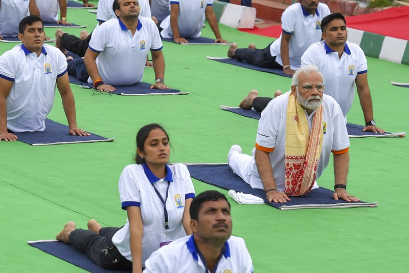 India's Prime Minister Narendra Modi (C) performs yoga with others to celebrate the International Day of Yoga in front of the Mysore Palace in Mysore on June 21, 2022. (Photo by Manjunath Kiran / AFP) (Photo by MANJUNATH KIRAN/AFP via Getty Images)