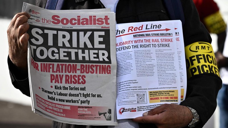 Pamphlets and newspapers are distributed at a picket line outside Waterloo Station in London on June 21, 2022 as the biggest rail strike in over 30 years hits the UK. - Rush-hour commuters in the UK faced chaos as railway workers began the network's biggest strike action in more than three decades, with a cost-of-living crisis threatening wider industrial action. (Photo by Ben Stansall / AFP) (Photo by BEN STANSALL/AFP via Getty Images)