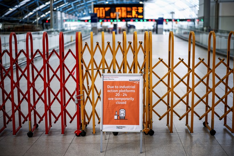 1241429779 Pamphlets and newspapers are distributed at a picket line outside Waterloo Station in London on June 21, 2022 as the biggest rail strike in over 30 years hits the UK. - Rush-hour commuters in the UK faced chaos as railway workers began the network's biggest strike action in more than three decades, with a cost-of-living crisis threatening wider industrial action. (Photo by Ben Stansall / AFP) (Photo by BEN STANSALL/AFP via Getty Images)