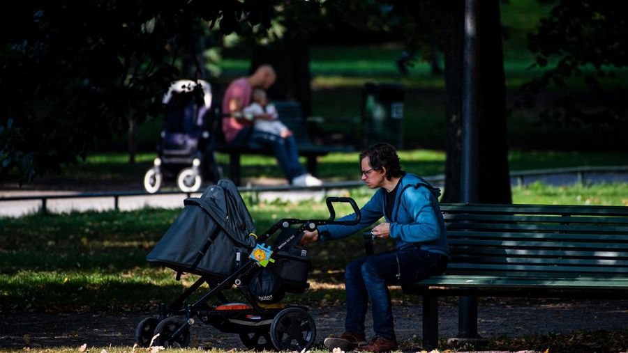 Two men take care of their babies at Humlegarden in Stockholm on September 24, 2020. - While France has just increased paternity leave to 28 days, in Sweden, a pioneer in gender equality, parents share 480 days off, which can be taken until the child's 12th birthday at 80% of the salary for the first 390 days and fathers have a minimum of three months, but only half of them take full advantage of it. (Photo by Jonathan NACKSTRAND / AFP) (Photo by JONATHAN NACKSTRAND/AFP via Getty Images)