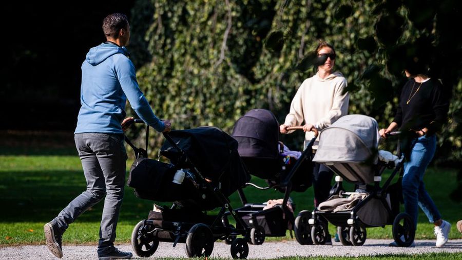 A man walks his baby in a baby stroller at Humlegarden in Stockholm on September 24, 2020. - While France has just increased paternity leave to 28 days, in Sweden, a pioneer in gender equality, parents share 480 days off, which can be taken until the child's 12th birthday at 80% of the salary for the first 390 days and fathers have a minimum of three months, but only half of them take full advantage of it. (Photo by Jonathan NACKSTRAND / AFP) (Photo by JONATHAN NACKSTRAND/AFP via Getty Images)