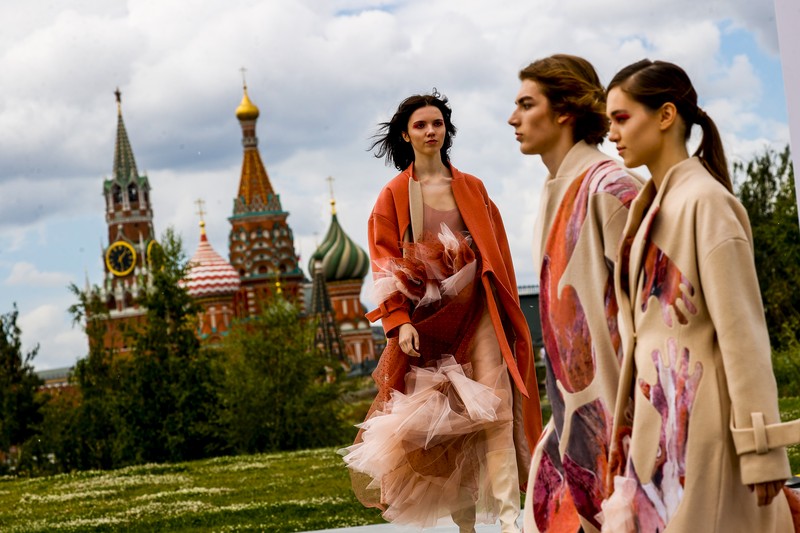 Russia Fashion Week Models display a collection by a group of Russian designers of the Moscow Art-Industrial Institute, during the Fashion Week at Zaryadye Park with the Spasskaya Tower and St. Basil's Cathedral on the left in background near Red Square in Moscow, Russia, Tuesday, June 21, 2022. (AP Photo/Alexander Zemlianichenko)