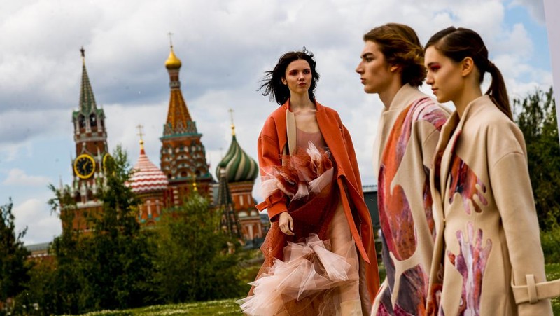 Models display a collection by a group of Russian designers of the Moscow Art-Industrial Institute, during the Fashion Week at Zaryadye Park with the Spasskaya Tower and St. Basil's Cathedral on the left in background near Red Square in Moscow, Russia, Tuesday, June 21, 2022. (AP Photo/Alexander Zemlianichenko)
