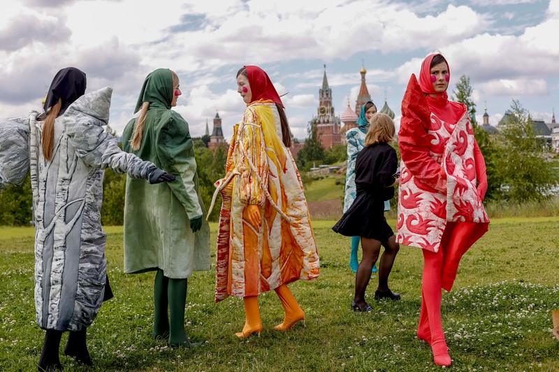 Russia Fashion Week Models display a collection by a group of Russian designers of the Moscow Art-Industrial Institute, during the Fashion Week at Zaryadye Park with the Spasskaya Tower and St. Basil's Cathedral on the left in background near Red Square in Moscow, Russia, Tuesday, June 21, 2022. (AP Photo/Alexander Zemlianichenko)