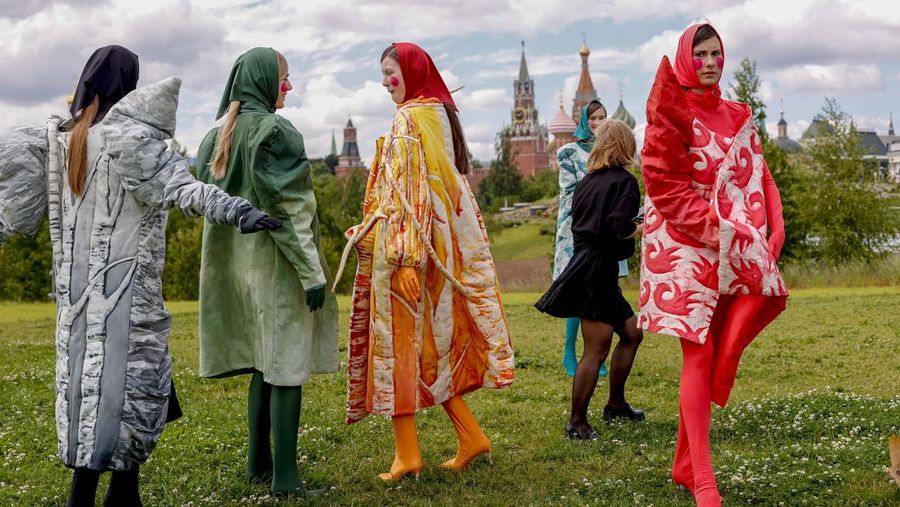 Models display a collection by a group of Russian designers of the Moscow Art-Industrial Institute, during the Fashion Week at Zaryadye Park with the Spasskaya Tower and St. Basil's Cathedral on the left in background near Red Square in Moscow, Russia, Tuesday, June 21, 2022. (AP Photo/Alexander Zemlianichenko)