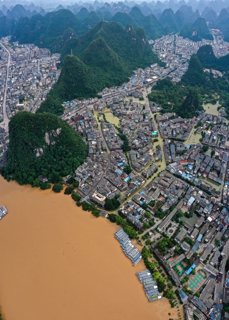 1404573199 QINGYUAN, CHINA - JUNE 22: Aerial view of residential houses surrounded by flood water after torrential rains on June 22, 2022 in Qingyuan, Guangdong Province of China. Flood control authority of China's Guangdong Province activated a Level-I emergency response on Tuesday. (Photo by VCG/VCG via Getty Images)