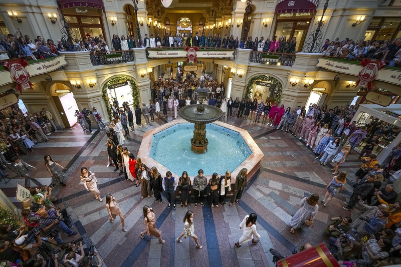 Models display a collection by a group of Russian designers of the Moscow Art-Industrial Institute, during the Fashion Week at Zaryadye Park with the Spasskaya Tower and St. Basil's Cathedral on the left in background near Red Square in Moscow, Russia, Tuesday, June 21, 2022. (AP Photo/Alexander Zemlianichenko)