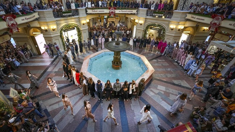 Models display a collection by a group of Russian designers of the Moscow Art-Industrial Institute, during the Fashion Week at Zaryadye Park with the Spasskaya Tower and St. Basil's Cathedral on the left in background near Red Square in Moscow, Russia, Tuesday, June 21, 2022. (AP Photo/Alexander Zemlianichenko)