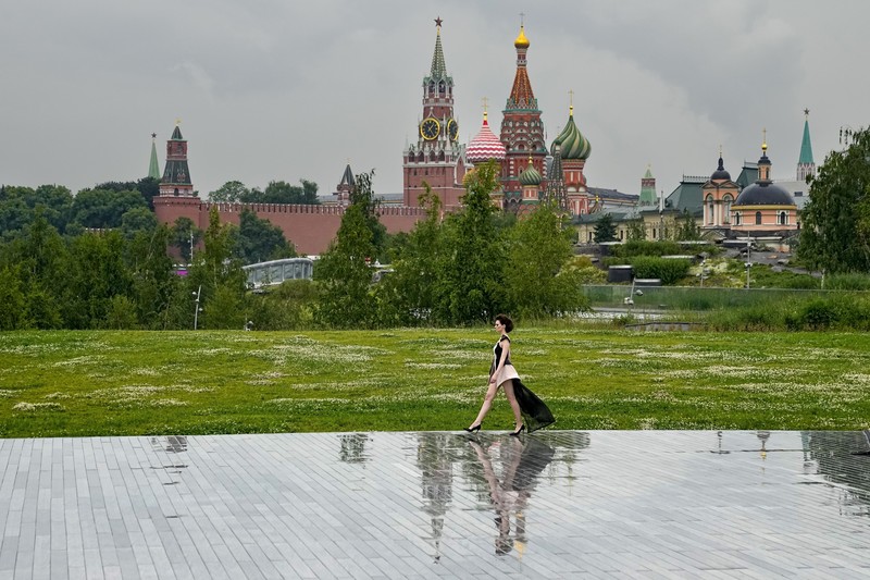 Russia Fashion Week Models display a collection by a group of Russian designers of the Moscow Art-Industrial Institute, during the Fashion Week at Zaryadye Park with the Spasskaya Tower and St. Basil's Cathedral on the left in background near Red Square in Moscow, Russia, Tuesday, June 21, 2022. (AP Photo/Alexander Zemlianichenko)