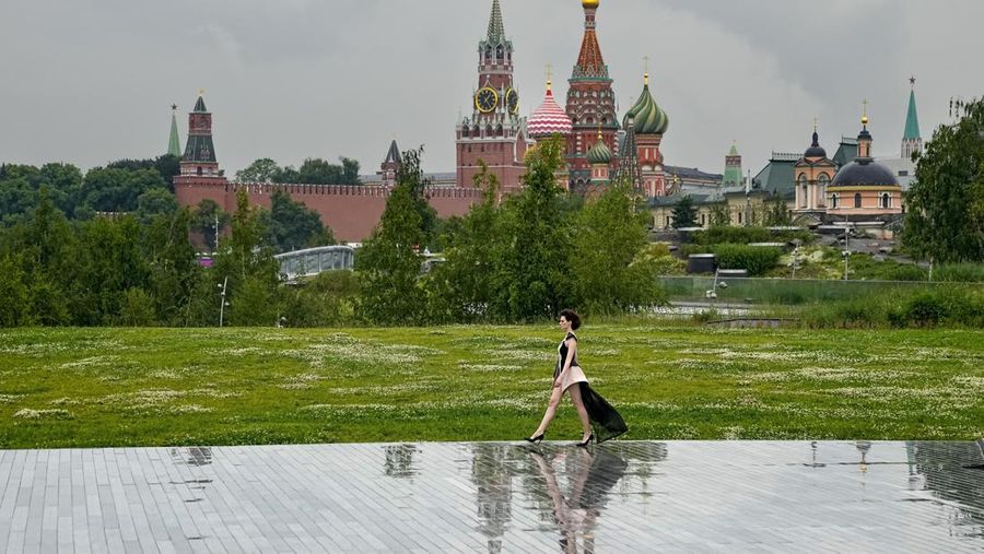 Models display a collection by a group of Russian designers of the Moscow Art-Industrial Institute, during the Fashion Week at Zaryadye Park with the Spasskaya Tower and St. Basil's Cathedral on the left in background near Red Square in Moscow, Russia, Tuesday, June 21, 2022. (AP Photo/Alexander Zemlianichenko)