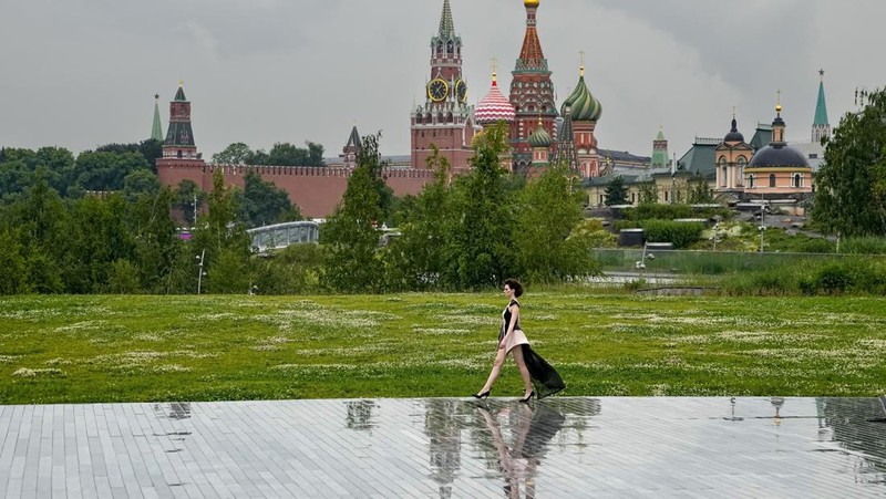Models display a collection by a group of Russian designers of the Moscow Art-Industrial Institute, during the Fashion Week at Zaryadye Park with the Spasskaya Tower and St. Basil's Cathedral on the left in background near Red Square in Moscow, Russia, Tuesday, June 21, 2022. (AP Photo/Alexander Zemlianichenko)