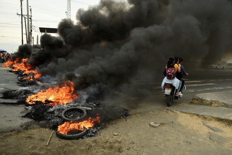 ECUADOR-PROTESTS/ A protester throws a tear gas canister fired by security personnel after Ecuador's armed forces warned they would not allow ongoing protests against President Guillermo Lasso's economic policies to damage the country's democracy, in Quito, Ecuador June 21, 2022. REUTERS/Santiago Arcos