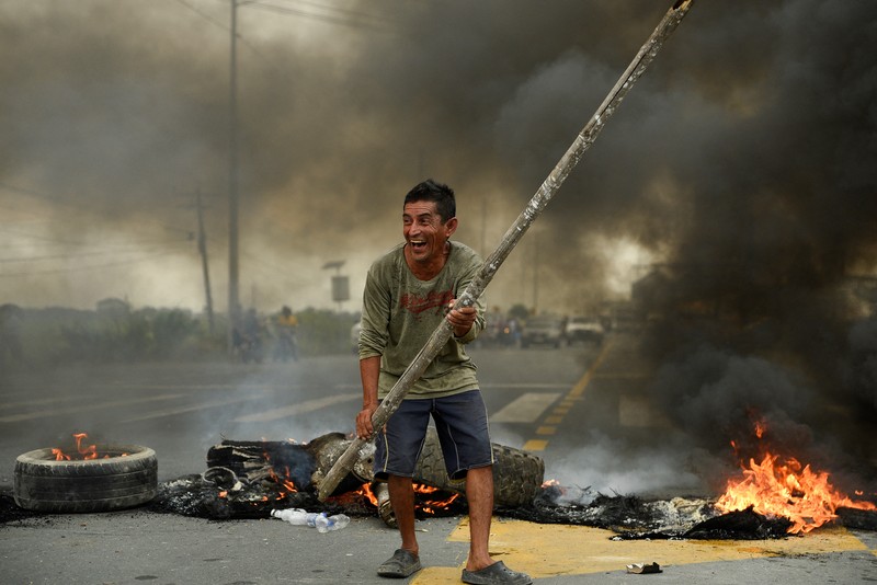 A protester throws a tear gas canister fired by security personnel after Ecuador's armed forces warned they would not allow ongoing protests against President Guillermo Lasso's economic policies to damage the country's democracy, in Quito, Ecuador June 21, 2022. REUTERS/Santiago Arcos