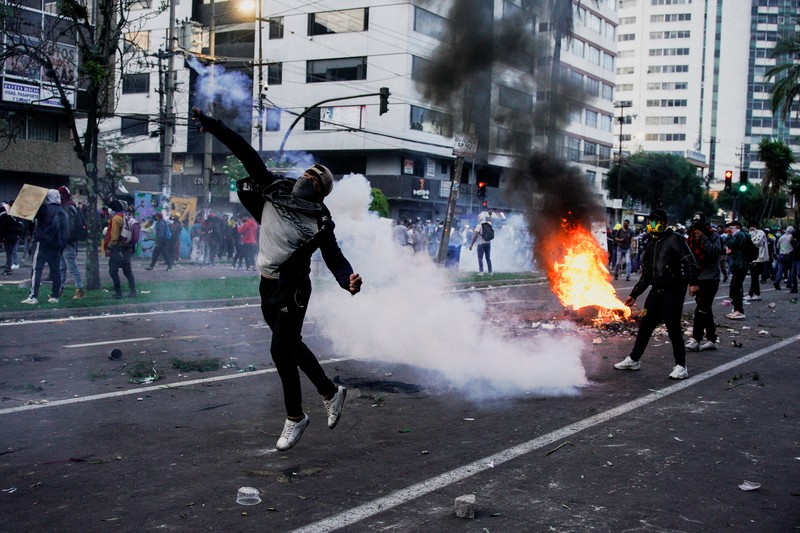 A protester throws a tear gas canister fired by security personnel after Ecuador's armed forces warned they would not allow ongoing protests against President Guillermo Lasso's economic policies to damage the country's democracy, in Quito, Ecuador June 21, 2022. REUTERS/Santiago Arcos
