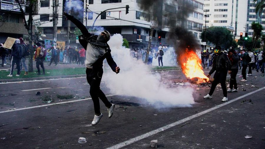 A protester throws a tear gas canister fired by security personnel after Ecuador's armed forces warned they would not allow ongoing protests against President Guillermo Lasso's economic policies to damage the country's democracy, in Quito, Ecuador June 21, 2022. REUTERS/Santiago Arcos
