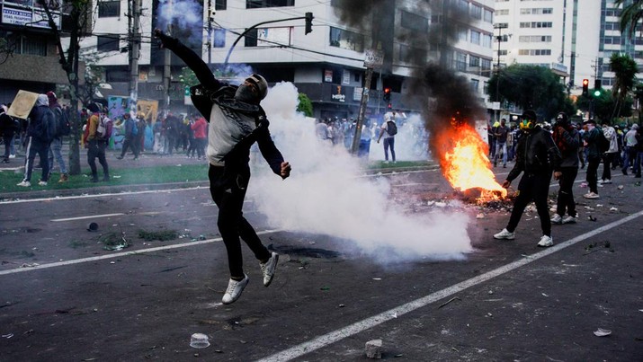 A protester throws a tear gas canister fired by security personnel after Ecuador's armed forces warned they would not allow ongoing protests against President Guillermo Lasso's economic policies to damage the country's democracy, in Quito, Ecuador June 21, 2022. REUTERS/Santiago Arcos