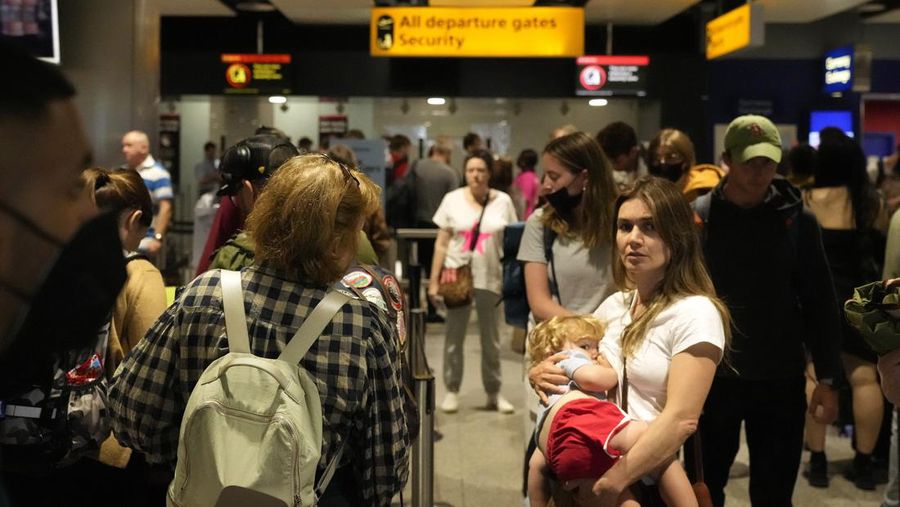 FILE - Travellers queue at security at Heathrow Airport in London, Wednesday, June 22, 2022. After two years of pandemic restrictions, travel demand is back with a vengeance but airlines and airports that slashed jobs during the depths of the COVID-19 crisis are struggling to keep up. With the busy summer tourism season underway in Europe, passengers are encountering chaotic scenes at airports, including lengthy delays, canceled flights and headaches over lost luggage. (AP Photo/Frank Augstein, File)