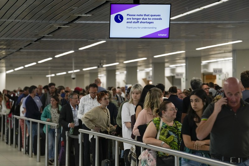 FILE - Travellers queue at security at Heathrow Airport in London, Wednesday, June 22, 2022. People face travelling disruption and long queues at airports amid the industry's ongoing staffing crisis. After two years of pandemic restrictions, travel demand is back with a vengeance but airlines and airports that slashed jobs during the depths of the COVID-19 crisis are struggling to keep up. With the busy summer tourism season underway in Europe, passengers are encountering chaotic scenes at airports, including lengthy delays, canceled flights and headaches over lost luggage. (AP Photo/Frank Augstein, File)