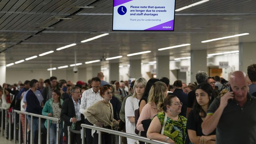 FILE - Travellers queue at security at Heathrow Airport in London, Wednesday, June 22, 2022. People face travelling disruption and long queues at airports amid the industry's ongoing staffing crisis. After two years of pandemic restrictions, travel demand is back with a vengeance but airlines and airports that slashed jobs during the depths of the COVID-19 crisis are struggling to keep up. With the busy summer tourism season underway in Europe, passengers are encountering chaotic scenes at airports, including lengthy delays, canceled flights and headaches over lost luggage. (AP Photo/Frank Augstein, File)