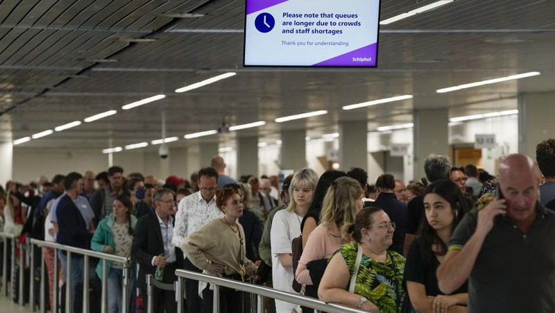 FILE - Travellers queue at security at Heathrow Airport in London, Wednesday, June 22, 2022. People face travelling disruption and long queues at airports amid the industry's ongoing staffing crisis. After two years of pandemic restrictions, travel demand is back with a vengeance but airlines and airports that slashed jobs during the depths of the COVID-19 crisis are struggling to keep up. With the busy summer tourism season underway in Europe, passengers are encountering chaotic scenes at airports, including lengthy delays, canceled flights and headaches over lost luggage. (AP Photo/Frank Augstein, File)