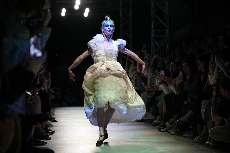 Russia Fashion Week Models display a collection by a group of Russian designers of the Moscow Art-Industrial Institute, during the Fashion Week at Zaryadye Park with the Spasskaya Tower and St. Basil's Cathedral on the left in background near Red Square in Moscow, Russia, Tuesday, June 21, 2022. (AP Photo/Alexander Zemlianichenko)