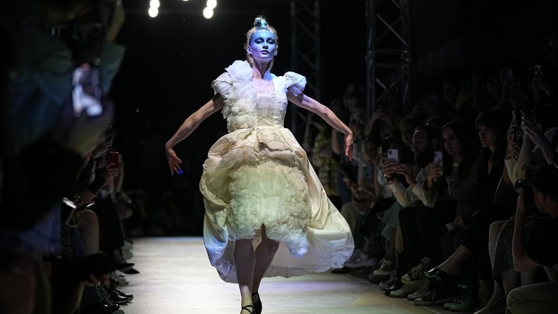 Models display a collection by a group of Russian designers of the Moscow Art-Industrial Institute, during the Fashion Week at Zaryadye Park with the Spasskaya Tower and St. Basil's Cathedral on the left in background near Red Square in Moscow, Russia, Tuesday, June 21, 2022. (AP Photo/Alexander Zemlianichenko)