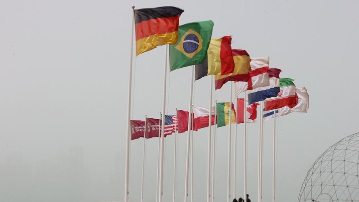 1240720387 The flags of nations taking part in the Qatar 2022 FIFA World Cup fly in Qatar's capital Doha during a heavy dust storm on May 17, 2022 as the skyline behind is obscured in the haze. (Photo by KARIM JAAFAR / AFP) (Photo by KARIM JAAFAR/AFP via Getty Images)