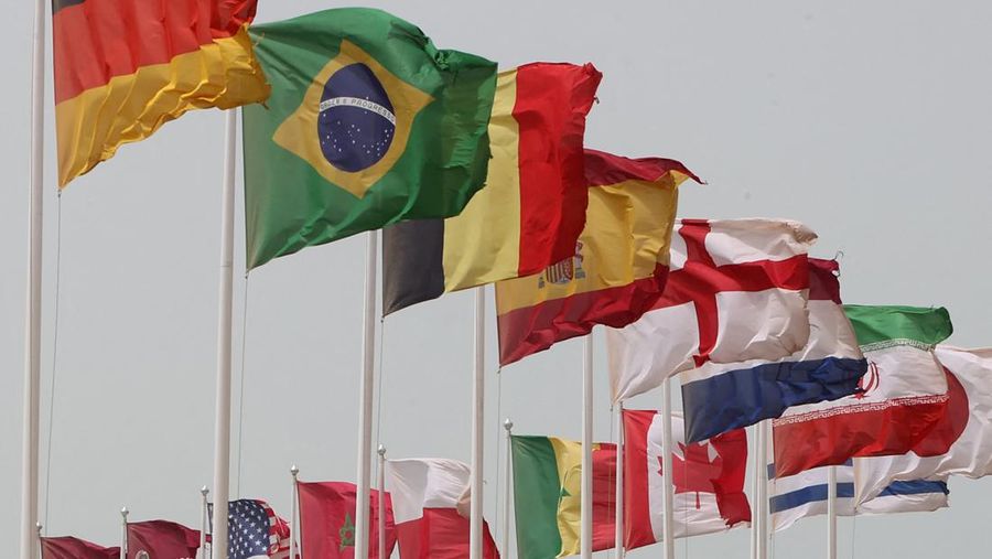 The flags of nations taking part in the Qatar 2022 FIFA World Cup fly in Qatar's capital Doha during a heavy dust storm on May 17, 2022 as the skyline behind is obscured in the haze. (Photo by KARIM JAAFAR / AFP) (Photo by KARIM JAAFAR/AFP via Getty Images)