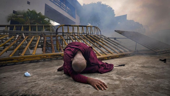 FILE- A Buddhist nun falls next to a barricade after inhaling tear gas during a protest against the economic crisis, outside police headquarters in Colombo, Sri Lanka, June 9, 2022. Lebanon and Sri Lanka may be a world apart, but they share a history of political turmoil and violence that led to the collapse of once-prosperous economies bedeviled by corruption, patronage, nepotism and incompetence. (AP Photo/Eranga Jayawardena, File)