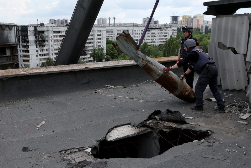 Members of a specialised team that defuses and removes explosives, bombs, mines and other munitions remove a defused 500kg bomb that did not detonate when it landed on an apartment building in March, in the Saltivka neighbourhood, as Russia’s attack on Ukraine continues, in Kharkiv, Ukraine, June 23, 2022. REUTERS/Leah Millis