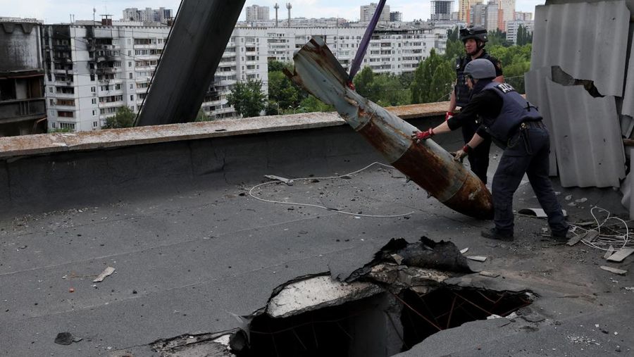 Members of a specialised team that defuses and removes explosives, bombs, mines and other munitions remove a defused 500kg bomb that did not detonate when it landed on an apartment building in March, in the Saltivka neighbourhood, as Russia’s attack on Ukraine continues, in Kharkiv, Ukraine, June 23, 2022. REUTERS/Leah Millis