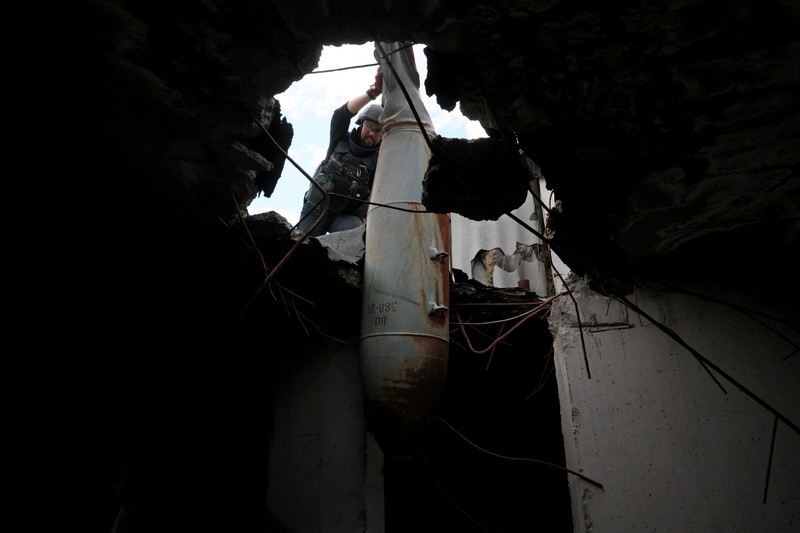 UKRAINE-CRISIS/ Members of a specialised team that defuses and removes explosives, bombs, mines and other munitions remove a defused 500kg bomb that did not detonate when it landed on an apartment building in March, in the Saltivka neighbourhood, as Russia’s attack on Ukraine continues, in Kharkiv, Ukraine, June 23, 2022. REUTERS/Leah Millis
