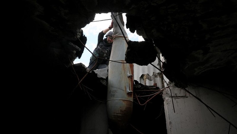 Members of a specialised team that defuses and removes explosives, bombs, mines and other munitions remove a defused 500kg bomb that did not detonate when it landed on an apartment building in March, in the Saltivka neighbourhood, as Russia’s attack on Ukraine continues, in Kharkiv, Ukraine, June 23, 2022. REUTERS/Leah Millis