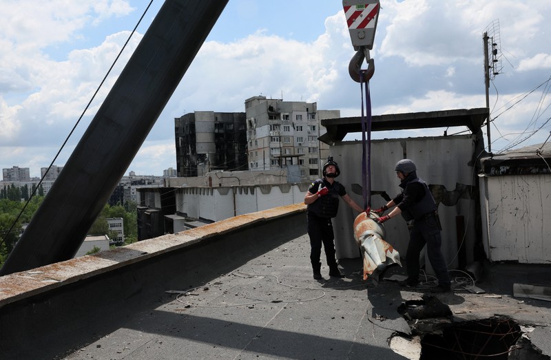 Members of a specialised team that defuses and removes explosives, bombs, mines and other munitions remove a defused 500kg bomb that did not detonate when it landed on an apartment building in March, in the Saltivka neighbourhood, as Russia’s attack on Ukraine continues, in Kharkiv, Ukraine, June 23, 2022. REUTERS/Leah Millis