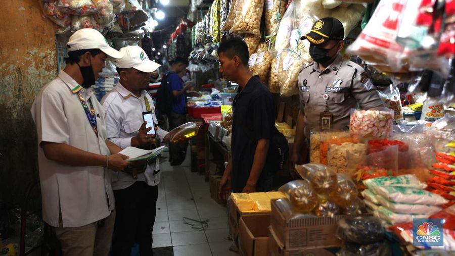 Karyawan Pasar Jaya mensosialisasikan kepada pedagang minyak di Pasar Kebayoran Lama, Jakarta, Senin (27/6/2022). Aplikasi PeduliLindungi saat ini menjadi syarat untuk membeli minyak goreng curah, sesuai dengan kebijakan pemerintah yang baru. (CNBC Indonesia/Muhammad Sabki)