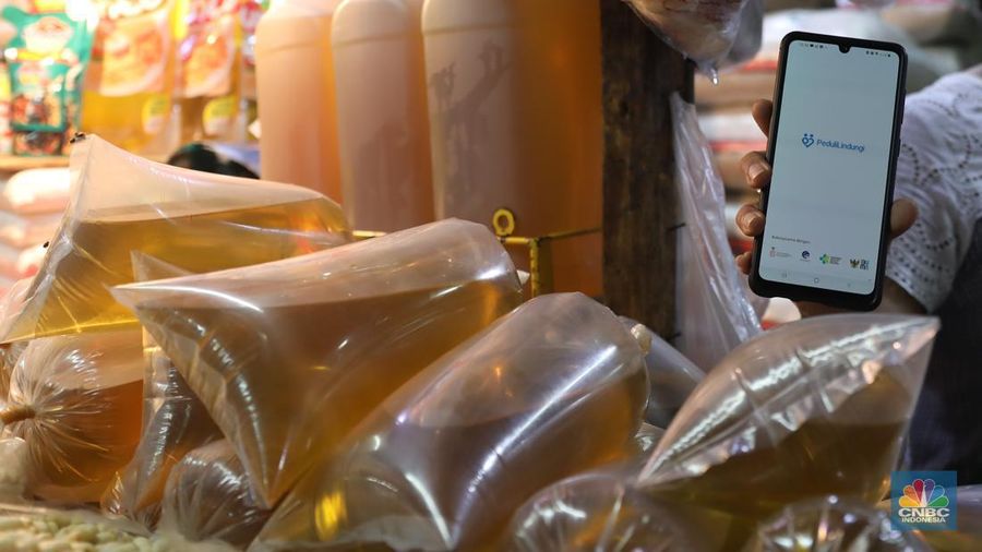Karyawan Pasar Jaya mensosialisasikan kepada pedagang minyak di Pasar Kebayoran Lama, Jakarta, Senin (27/6/2022). Aplikasi PeduliLindungi saat ini menjadi syarat untuk membeli minyak goreng curah, sesuai dengan kebijakan pemerintah yang baru. (CNBC Indonesia/Muhammad Sabki)