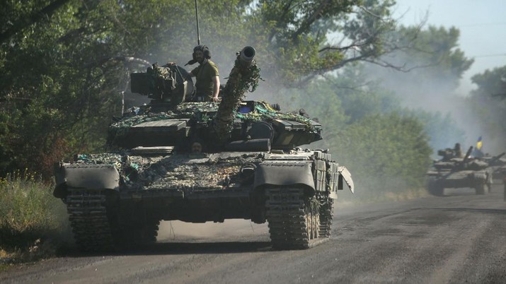 Pasukan Ukraina bergerak dengan tank di jalan di wilayah timur Ukraina. (AFP via Getty Images/ANATOLII STEPANOV)