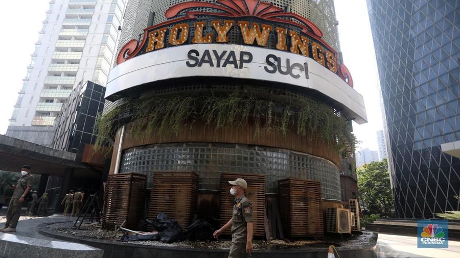 Petugas Satpol PP memasang spanduk penutupan Holywings Epicentrum, Jakarta, Selasa (28/6/2022). (CNBC Indonesia/Andrean Kristianto)