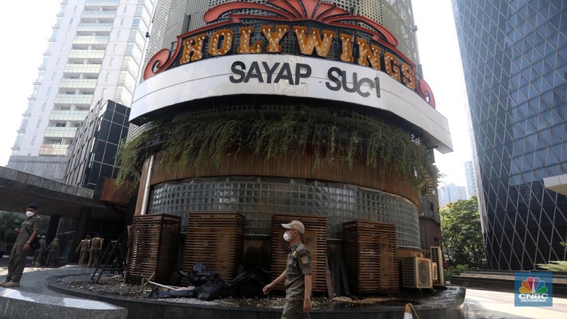 Petugas Satpol PP memasang spanduk penutupan Holywings Epicentrum, Jakarta, Selasa (28/6/2022). (CNBC Indonesia/Andrean Kristianto)